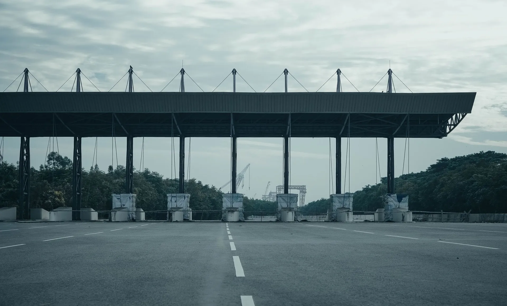 Pórtico de una autopista vacía, sin barrera física, bajo un cielo nublado.